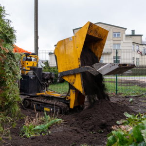 Dumper truck dumping soil on construction site protected by a vehicle tracking system.